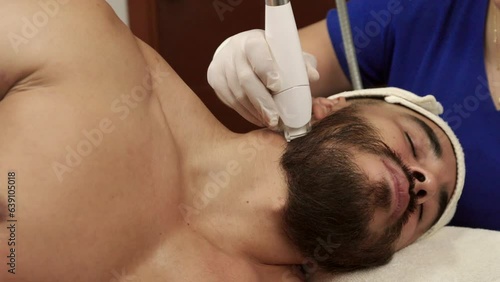 Male mexican latin guest receives anti aging treatment in the neck at spa wellness center endermologie lpg muscle handsome model photo