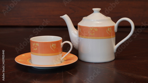 Teapot set as seen from above on a dark wood dining room table.