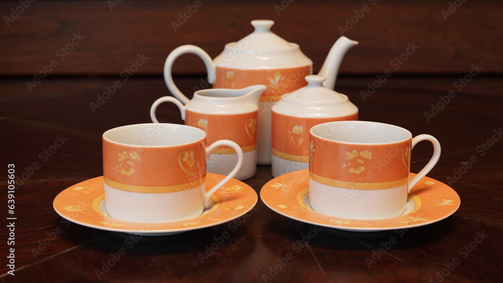 Obraz premium Teapot set as seen from above on a dark wood dining room table.