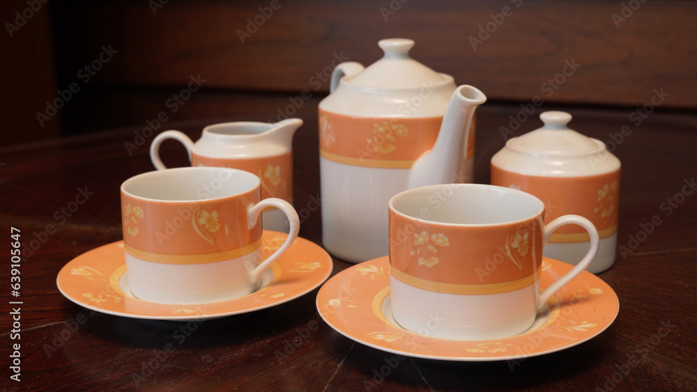 Obraz premium Teapot set as seen from above on a dark wood dining room table.