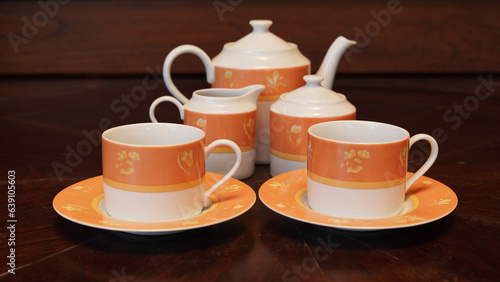 Teapot set as seen from above on a dark wood dining room table.