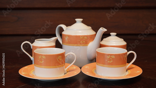 Teapot set as seen from above on a dark wood dining room table.
