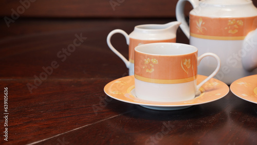 Teapot set as seen from above on a dark wood dining room table.