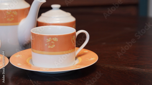 Teapot set as seen from above on a dark wood dining room table.