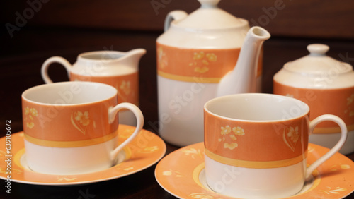 Teapot set as seen from above on a dark wood dining room table.