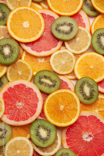 top down background view made of Fresh Sliced organic kiwi, oranges and lemons close-up