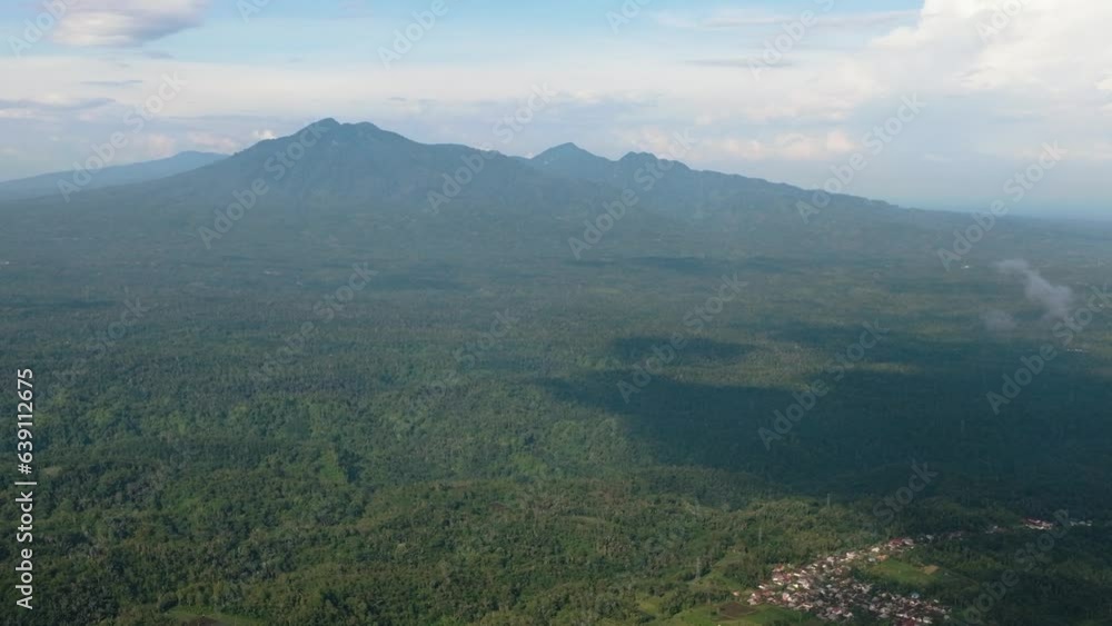 Top view of jungle and mountains in Sumatra. Mountain slopes with tropical vegetation. Indonesia. Top view of jungle and mountains in Sumatra. Mountain slopes with tropical vegetation. Indonesia.
