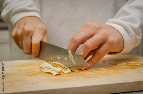Female cutting tofu skin on chopping board