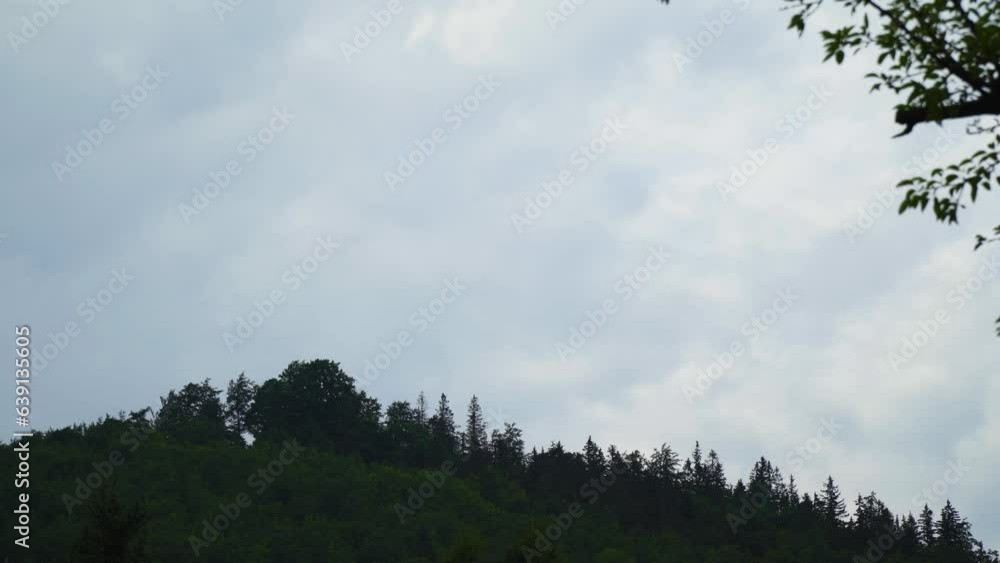 Timelapse of a mountain overgrown with trees and giant moving clouds above moving very quickly from day to evening looking scary prophesy of the bible son of man coming on a cloud to judge the living Timelapse of a mountain overgrown with trees and giant moving clouds above moving very quickly from day to evening looking scary prophesy of the bible son of man coming on a cloud to judge the living