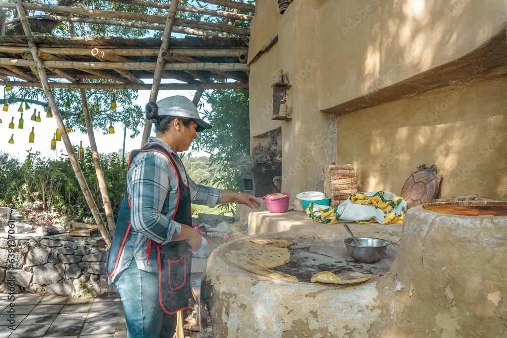 Culinary Traditions: Cook Woman Preparing Tlacoyos on Clay Griddle Culinary Traditions: Cook Woman Preparing Tlacoyos on Clay Griddle