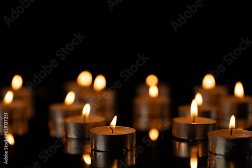 Lit tea candles with copy space on black background