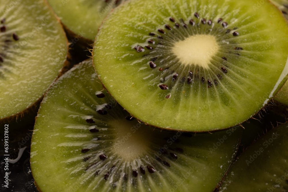 Micro close up of sliced kiwi fruits with water drops and copy space on black background Micro close up of sliced kiwi fruits with water drops and copy space on black background