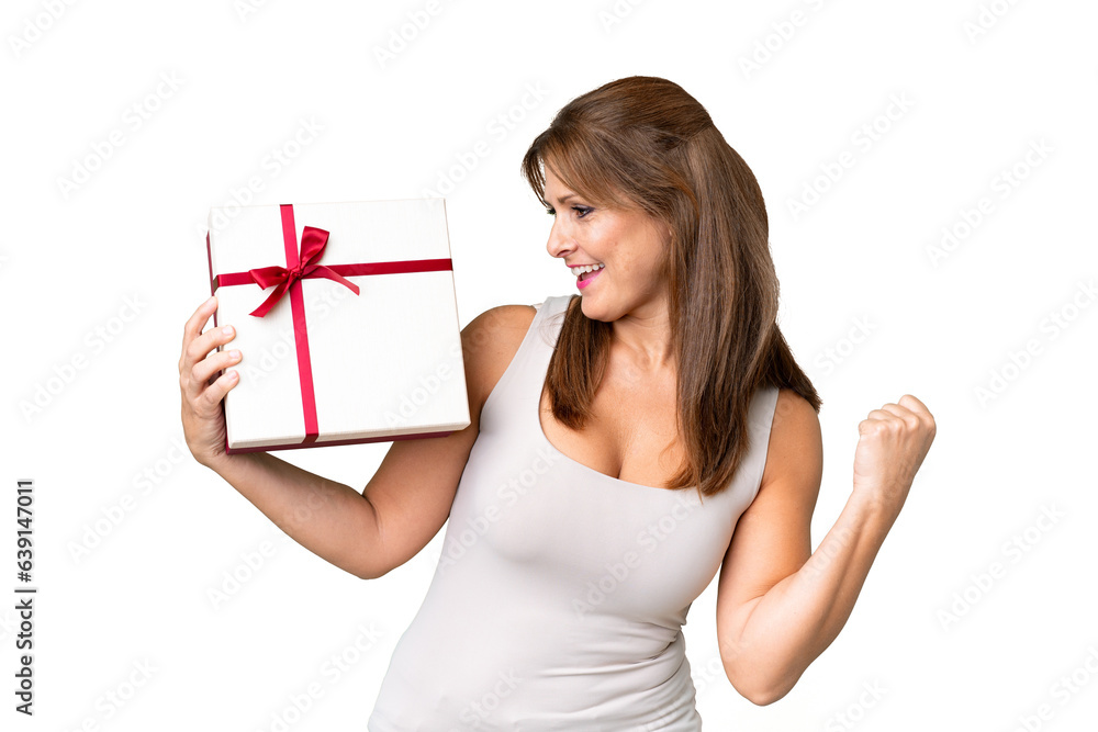 Middle age caucasian woman holding a gift over isolated background celebrating a victory Middle age caucasian woman holding a gift over isolated background celebrating a victory