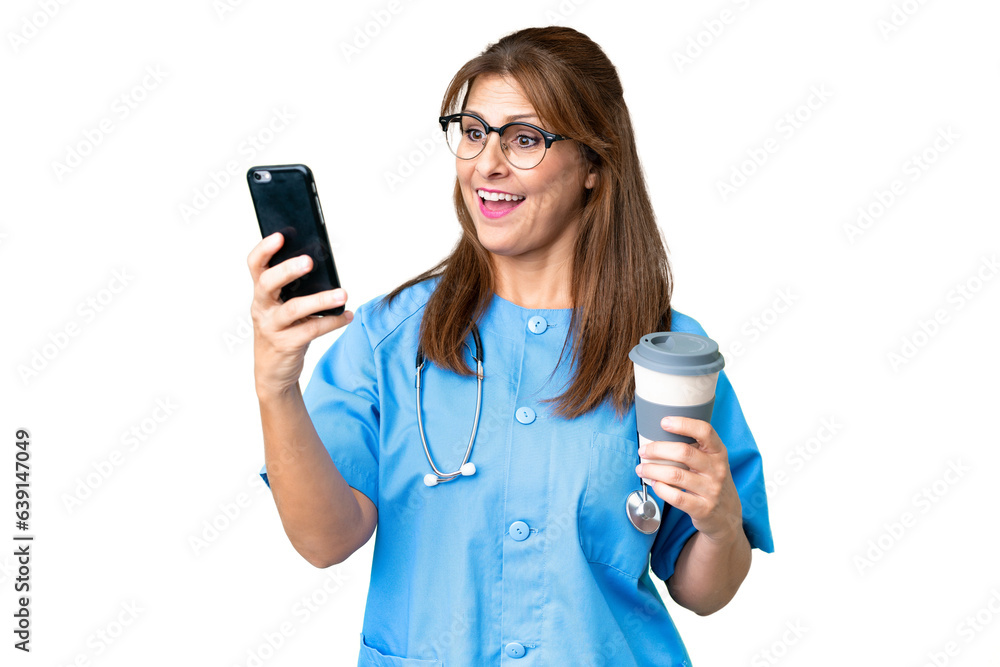 Middle age nurse woman over isolated background holding coffee to take away and a mobile Middle age nurse woman over isolated background holding coffee to take away and a mobile