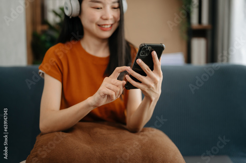Woman using smart phone for mobile payments online shopping, omni channel, sitting on table, virtual icons graphics interface screen ..