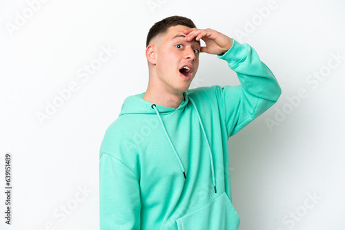 Young brazilian man isolated on white background doing surprise gesture while looking to the side © luismolinero