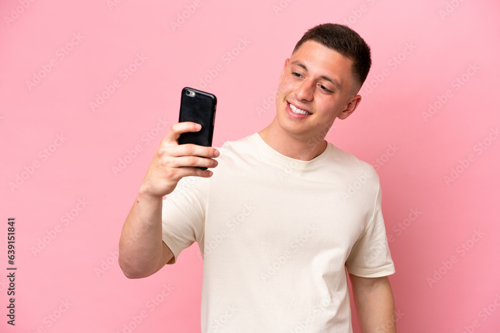 Young Brazilian man isolated on pink background making a selfie Young Brazilian man isolated on pink background making a selfie