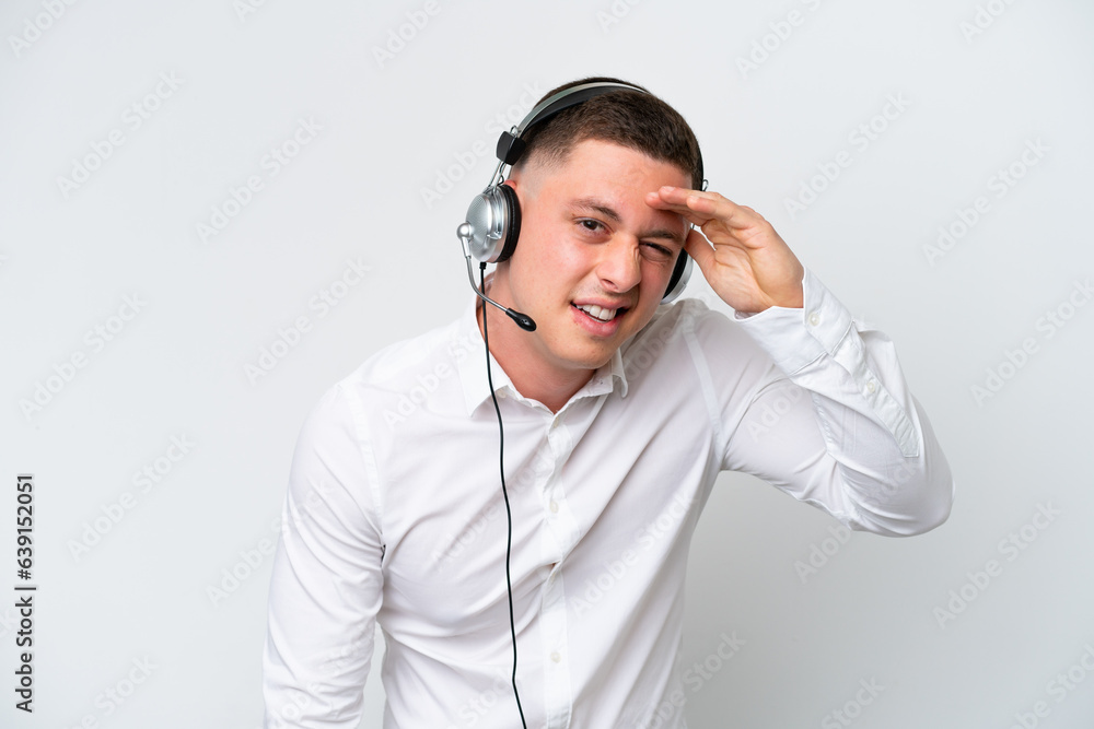 Telemarketer Brazilian man working with a headset isolated on white background looking far away with hand to look something Telemarketer Brazilian man working with a headset isolated on white background looking far away with hand to look something