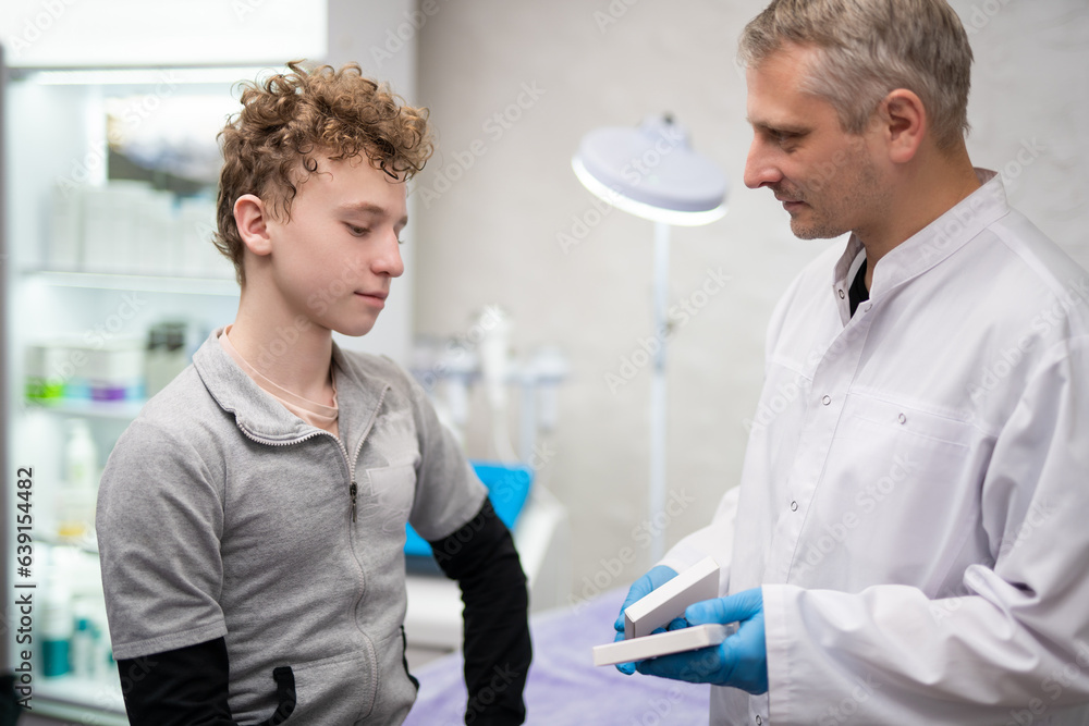 A man doctor talks to his boy patient and advises him on medicine A man doctor talks to his boy patient and advises him on medicine