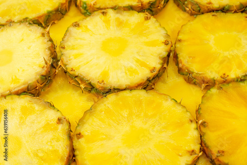 Pineapple juicy yellow slices as a background.