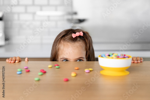 Young girl looking at candy on kitchen table