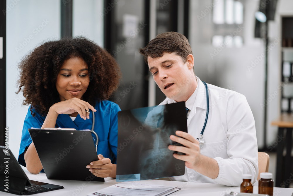 Medical team working on digital tablet healthcare doctor technology tablet using x-ray film analyzed the results of medical reports. Medical team working on digital tablet healthcare doctor technology tablet using x-ray film analyzed the results of medical reports.