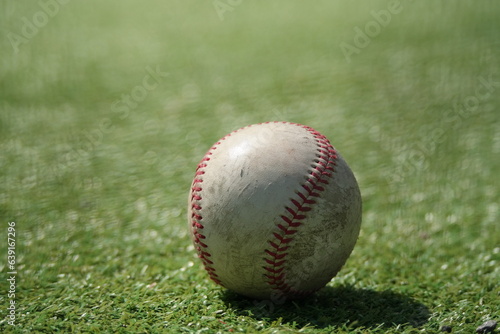 An old baseball lies on the lawn