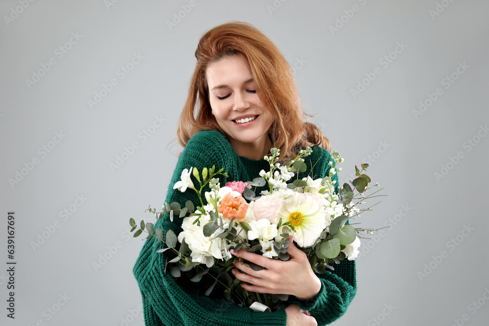 Beautiful woman with bouquet of flowers on grey background Beautiful woman with bouquet of flowers on grey background