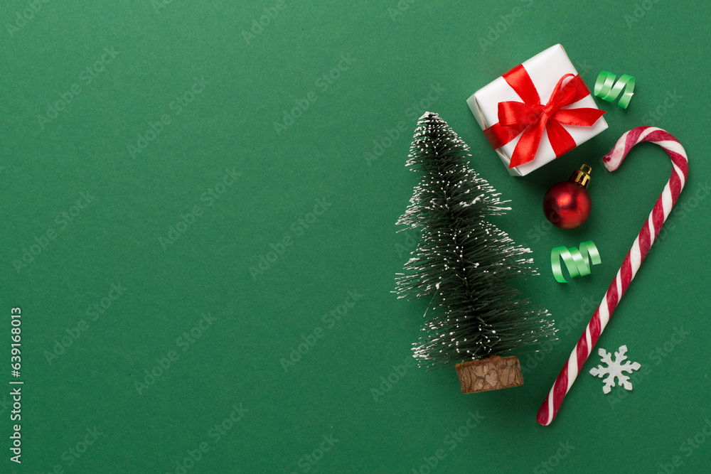 Miniature christmas tree with gift box and decor on color background Miniature christmas tree with gift box and decor on color background