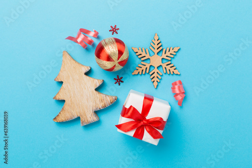 Miniature christmas tree with gift box and decor on color background