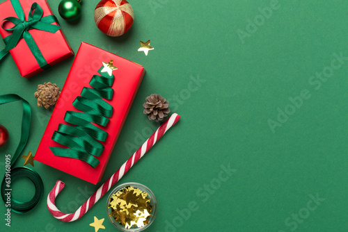 Gift boxes with paper's rools and christmas decoration on color background, top view