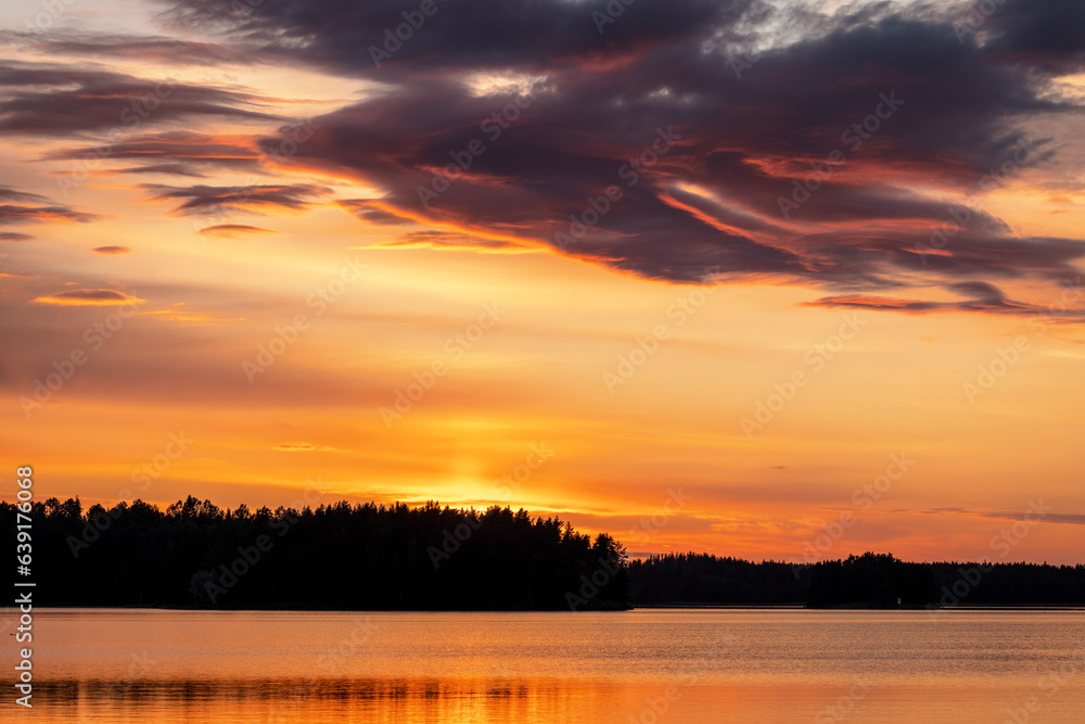 Sunset over finnish landscape with water and forest in summer, Karelia, Finland
