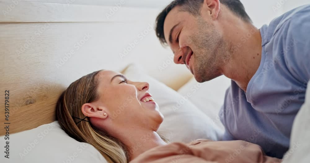 Laugh, relax and couple in conversation in bed for bonding, discussion or communication. Kiss, love and young man and woman talking with comic, comedy and funny joke together in the bedroom at home. Laugh, relax and couple in conversation in bed for bonding, discussion or communication. Kiss, love and young man and woman talking with comic, comedy and funny joke together in the bedroom at home.