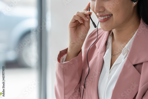 Asian businesswoman employee or executive using laptop computer and wearing headset video call explaining online meeting or online training. Document work in the office