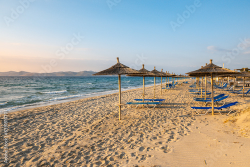 Fototapeta Naklejka Na Ścianę i Meble -  Straw umbrellas on sandy beach of Marmari. The Greek island of Kos