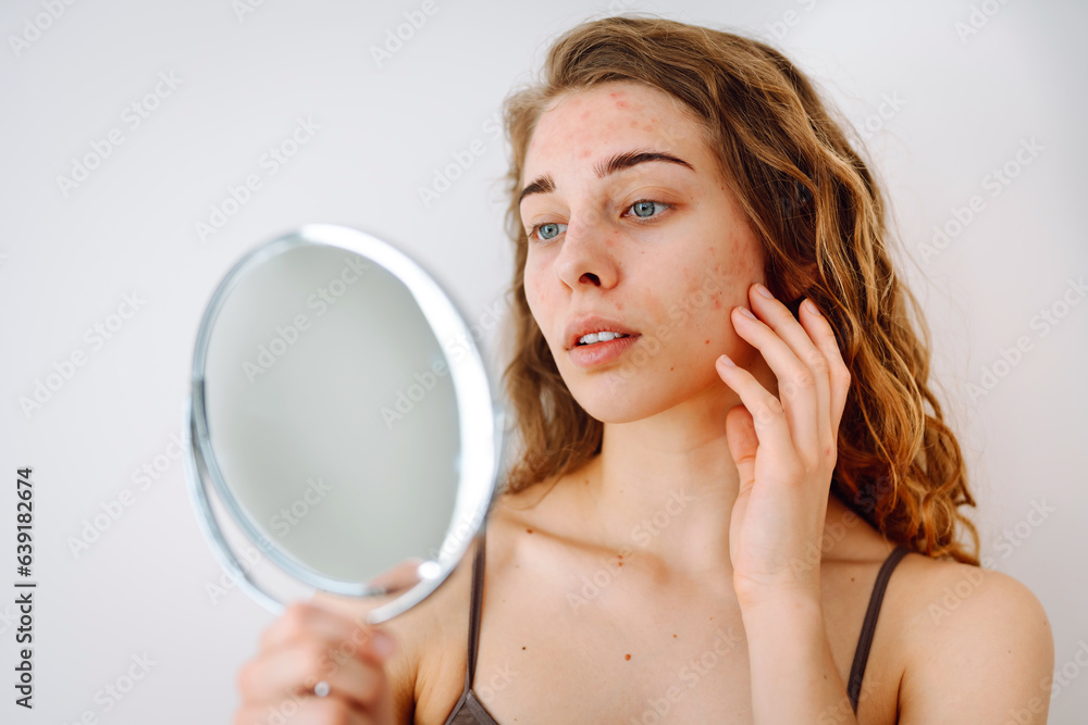 Beautiful woman with problematic skin works in her small mirror. Cosmetology. Skin care concept. Beautiful woman with problematic skin works in her small mirror. Cosmetology. Skin care concept.