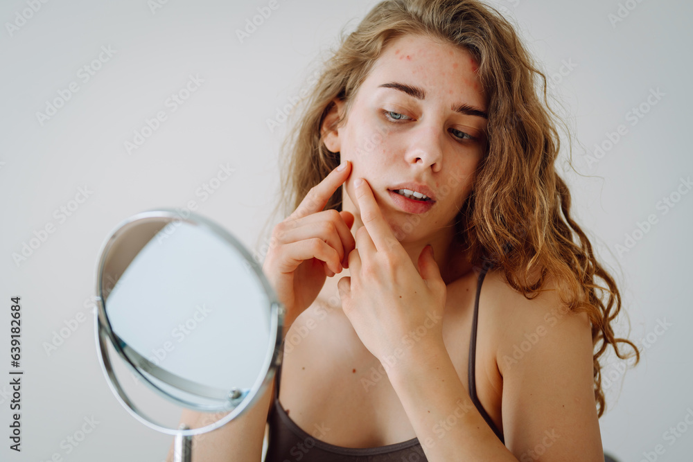 Beautiful woman with problematic skin works in her small mirror. Cosmetology. Skin care concept. Beautiful woman with problematic skin works in her small mirror. Cosmetology. Skin care concept.
