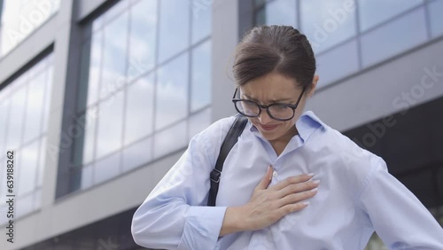 Anxious woman rubbing sore chest feeling pain, risk of heart attack, tachycardia