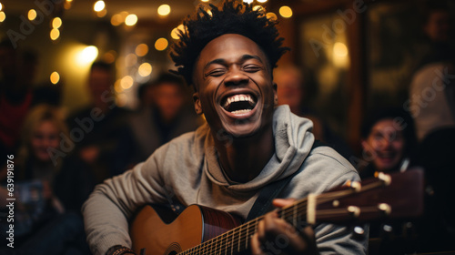 Young african american man playing guitar in pub. Cheerful young man with afro haircut singing song.
