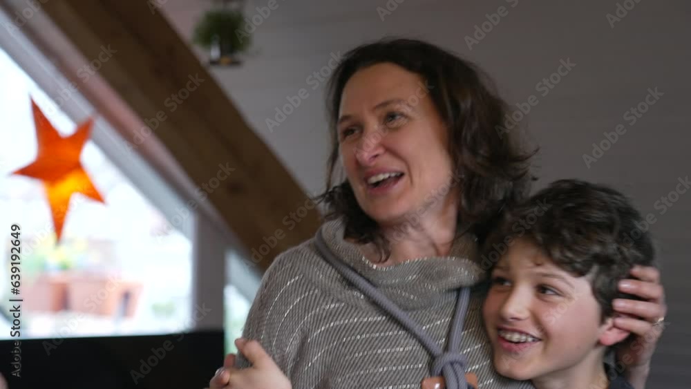 Candid mother and pre-teen boy laughing together. Authentic moment of family lifestyle joy with child with arm around mom in affectionate embrace Candid mother and pre-teen boy laughing together. Authentic moment of family lifestyle joy with child with arm around mom in affectionate embrace