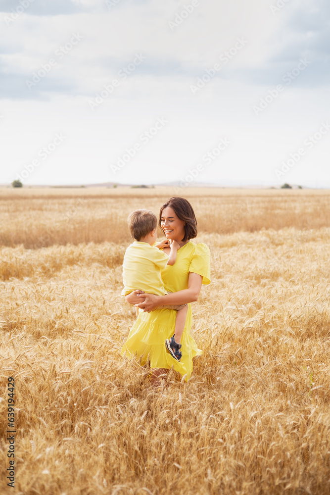 Happy family. Young mother throws up baby in the sky, on sunny day. Portrait mother and little son on the Field. Positive human emotions, feelings, emotions Happy family. Young mother throws up baby in the sky, on sunny day. Portrait mother and little son on the Field. Positive human emotions, feelings, emotions