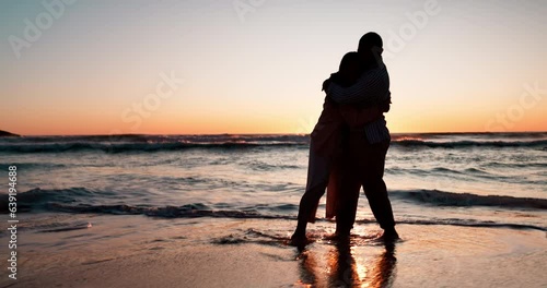 Couple, running and hug by beach in sunset, silhouette or game with love, romance or bonding on vacation. Man, woman and outdoor by waves, sea or dusk on holiday, honeymoon or comic together by ocean photo