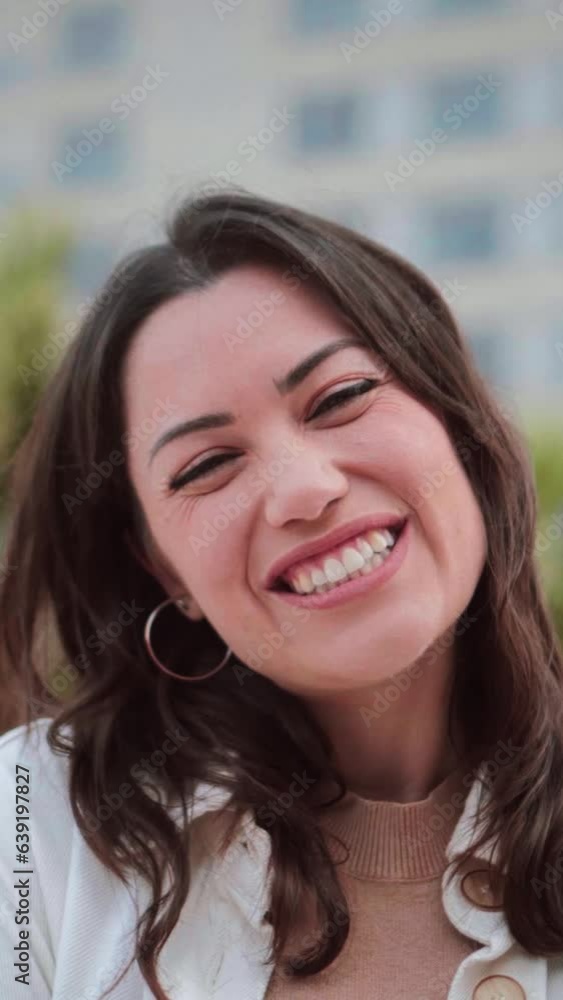 Vertical individual close up portrait of young woman smiling and looking at camera with white tooth standing outdoors. Front view of happy teenage girl with positive attitude. High quality footage Vertical individual close up portrait of young woman smiling and looking at camera with white tooth standing outdoors. Front view of happy teenage girl with positive attitude. High quality footage