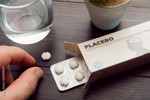 Placebo effect concept: man take a pill from a placebo box of pills photo