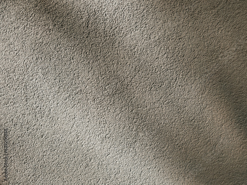 Cement plastered wall with deep abstract shadows on it. Beige background, concrete grunge texture.
