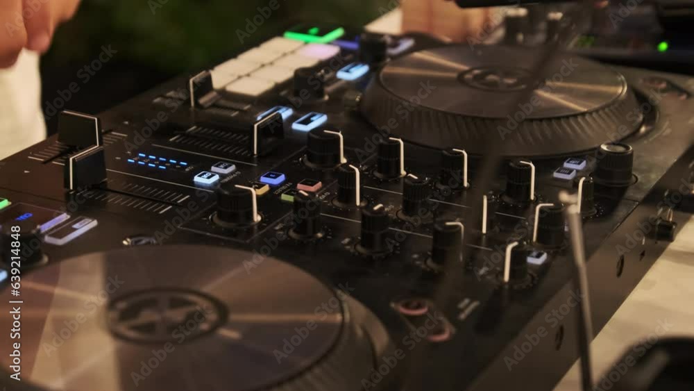 Vidéo Stock DJ plays music using DJ controller at night party. Mixing