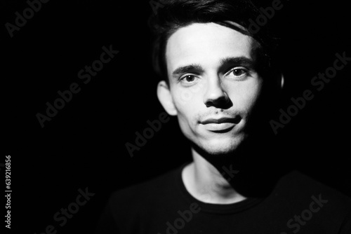 black and white portrait of a young guy on a black background
