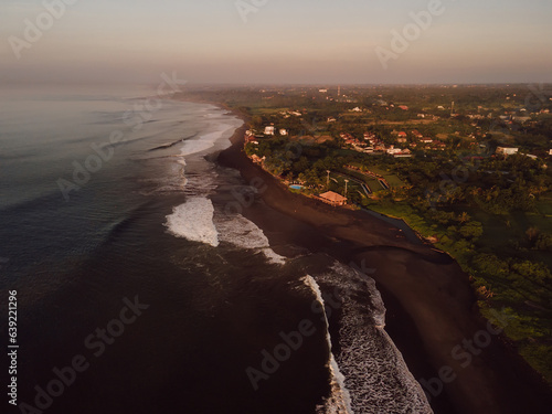 Aerial view of scenic beach with warm sunrise tones and ocean in Bali. Keramas beach