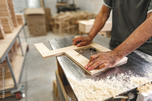 Unrecognizable man carpenter making wooden furniture in workshop