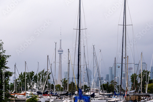 Photography masts in a marina blend with a big city skyline (background) on a foggy summer d